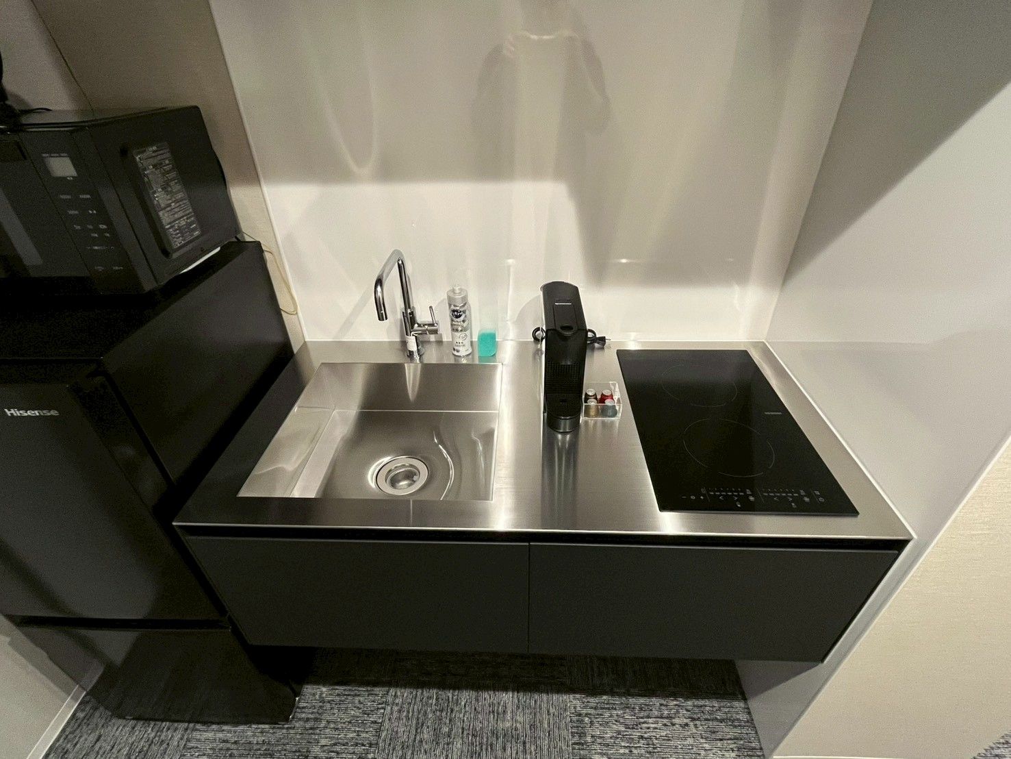 A modern kitchen with a built-in sink, a stove, and a coffee maker.
