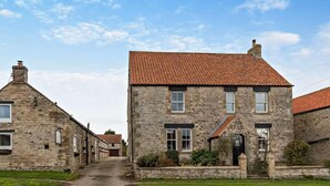 A stone building with a red-tiled roof, a narrow street, and a grassy area. - 6 Bed in Pickering (oc-96415) (Newton-on-Rawcliffe)
