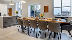 Una cucina moderna con zona pranzo, ampie finestre e vista sulla città.