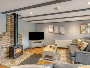 A living room with a fireplace, a television, a sofa, and a coffee table.