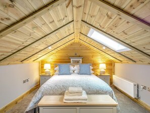 A bedroom with a sloped ceiling, a bed with pillows, bedside lamps, a radiator, and a skylight. - 2 Bed in Otley (oc-96431) (Norwood)