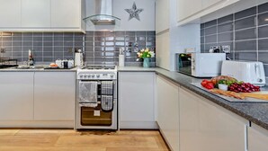 Een moderne keuken met een fornuis, oven, magnetron, en een ster decoratie aan de muur.