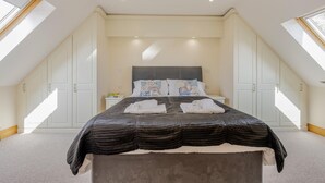 Une chambre à coucher avec un grand lit, une table de chevet et une armoire.