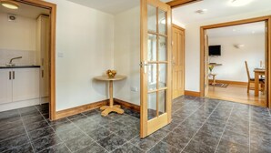 Um interior moderno com cozinha, área de refeições e uma grande porta de madeira.