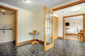 Ein modernes Interieur mit einer Küche, einem Essbereich und einer großen Holztür.