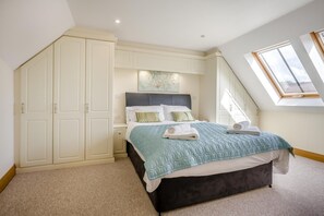 A bedroom with a bed, a wardrobe, a skylight, and a painting on the wall. - 2 Bed in Bridport (oc-regis) (Charmouth)