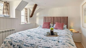 A bedroom with a bed, a window, a radiator, and a nightstand with a lamp. - 2 Bed in Kingsbridge (oc-94125) (Malborough)