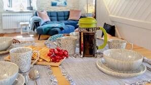 A cozy living room with a coffee table set for a meal, featuring a coffee pot, bowls, and snacks. - 2 Bed in Kingsbridge (oc-94125) (Malborough)