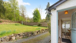 A stone wall, a gravel path, and a wooden fence in a garden. - 3 Bed in Ambleside (oc-96511) (Claife)