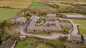 A rural farmstead with stone buildings, a paved driveway, and surrounding fields. - 2 Bed in Bude (oc-04727) (Poundstock)