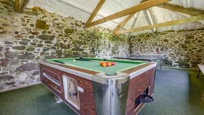 A pool table with a wooden frame and a green felt surface, surrounded by stone walls and a wooden ceiling structure. - 2 Bed in Bude (oc-04727) (Poundstock)