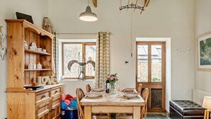 A dining area with a wooden table set for six, surrounded by wooden chairs. - 2 Bed in Bude (oc-04727) (Poundstock)