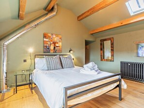 A bedroom with a bed, a glass table, a radiator, and a skylight. - 3 Bed in Bakewell (oc-96490) (Ashford in the Water)