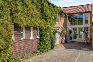 A house with a brick exterior, a wooden front, and a glass door entrance. - 2 Bed in Thetford (oc-57886) (Saham Toney)