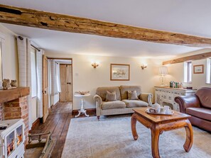 A cozy living room with a fireplace, a sofa, a coffee table, and a leather armchair. - 2 Bed in Thetford (oc-57886) (Saham Toney)