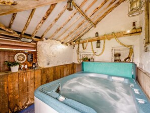 Une salle de bain rustique avec un plafond en bois, une baignoire et un lavabo fixé au mur.