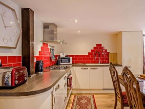 A compact kitchen with a microwave, toaster, and gas stove. - 2 Bed in Thetford (oc-57885) (Saham Toney)