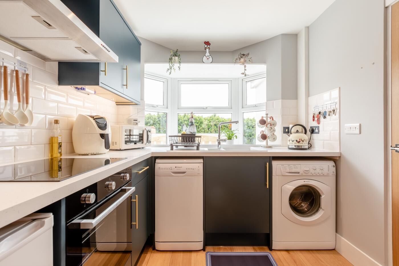 A modern kitchen with built-in appliances, a dishwasher, and a washing machine.
