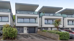 Un edificio residencial moderno con techo plano, ventanas grandes y garaje.