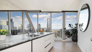 Een moderne keuken met uitzicht op de stad, grote ramen en een minimalistisch design.