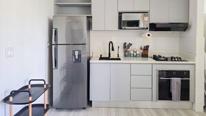 Eine moderne Küche mit einem Edelstahl-Kühlschrank, einer Mikrowelle, einem Gasherd und einem Backofen.