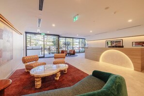 Eine moderne Lobby mit Empfangstresen, Sitzgelegenheiten und großen Fenstern.
