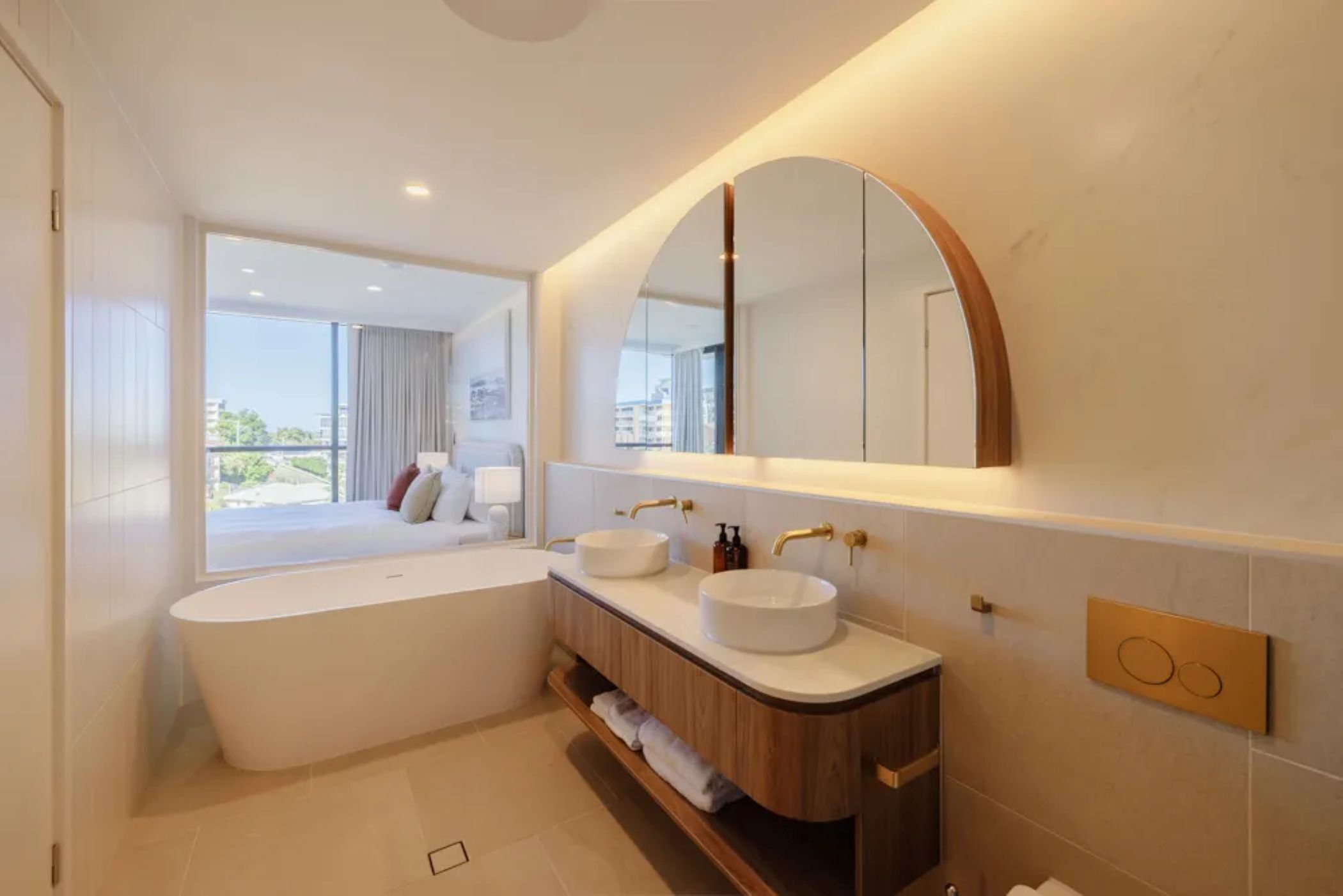 Une salle de bain moderne avec une baignoire, deux lavabos et un grand miroir.
