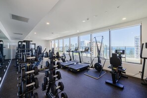 A gym with cardio machines, weightlifting equipment, and a treadmill.