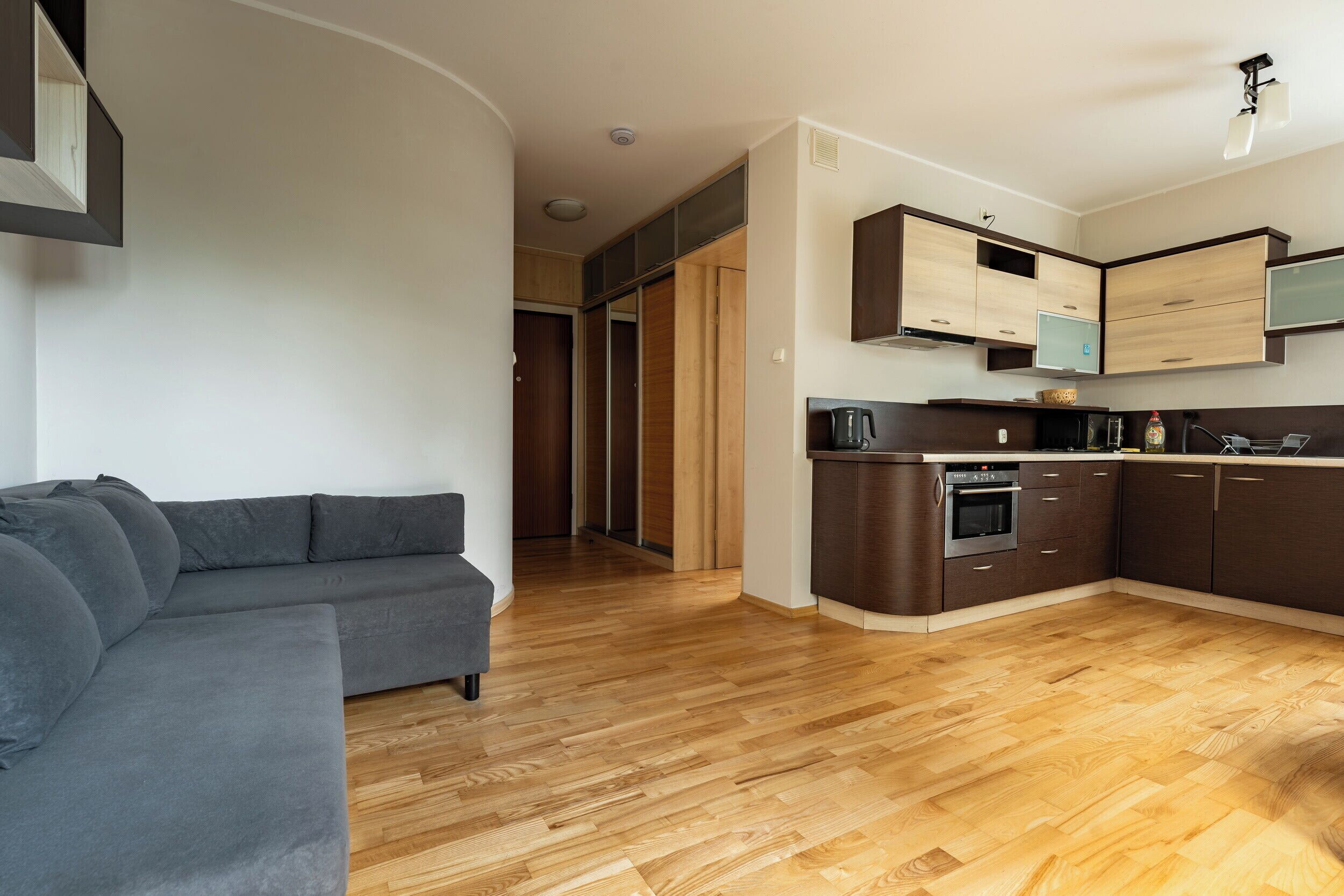 Een moderne keuken met houten kastjes en een ingebouwde oven.