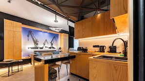 Una cucina moderna con mobili in legno, un piano di lavoro nero e una zona pranzo con divano e sedie.