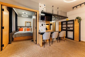 A compact room with a bed, a small kitchenette, and a dining area with chairs. - 100 Steps to Old Town Beza Apartment (Gdańsk)