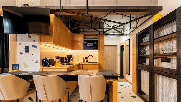 Una cucina moderna con angolo bar, mobili in legno e pavimento a parquet.