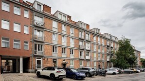 Una fila di edifici residenziali a più piani con un'area parcheggio antistante.
