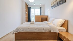 Ein Schlafzimmer mit einem hölzernen Bett, einem Nachttisch, einem Kleiderschrank und einem Bild an der Wand.