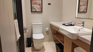Un baño moderno con inodoro, lavamanos y un cuadro en la pared.