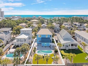 Un quartier résidentiel avec des maisons, une piscine et une vue sur l’océan.