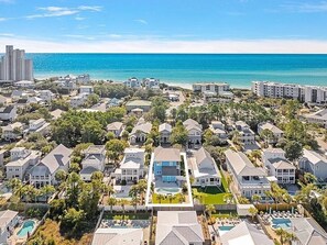Un barrio residencial con casas, una piscina y vistas al océano.