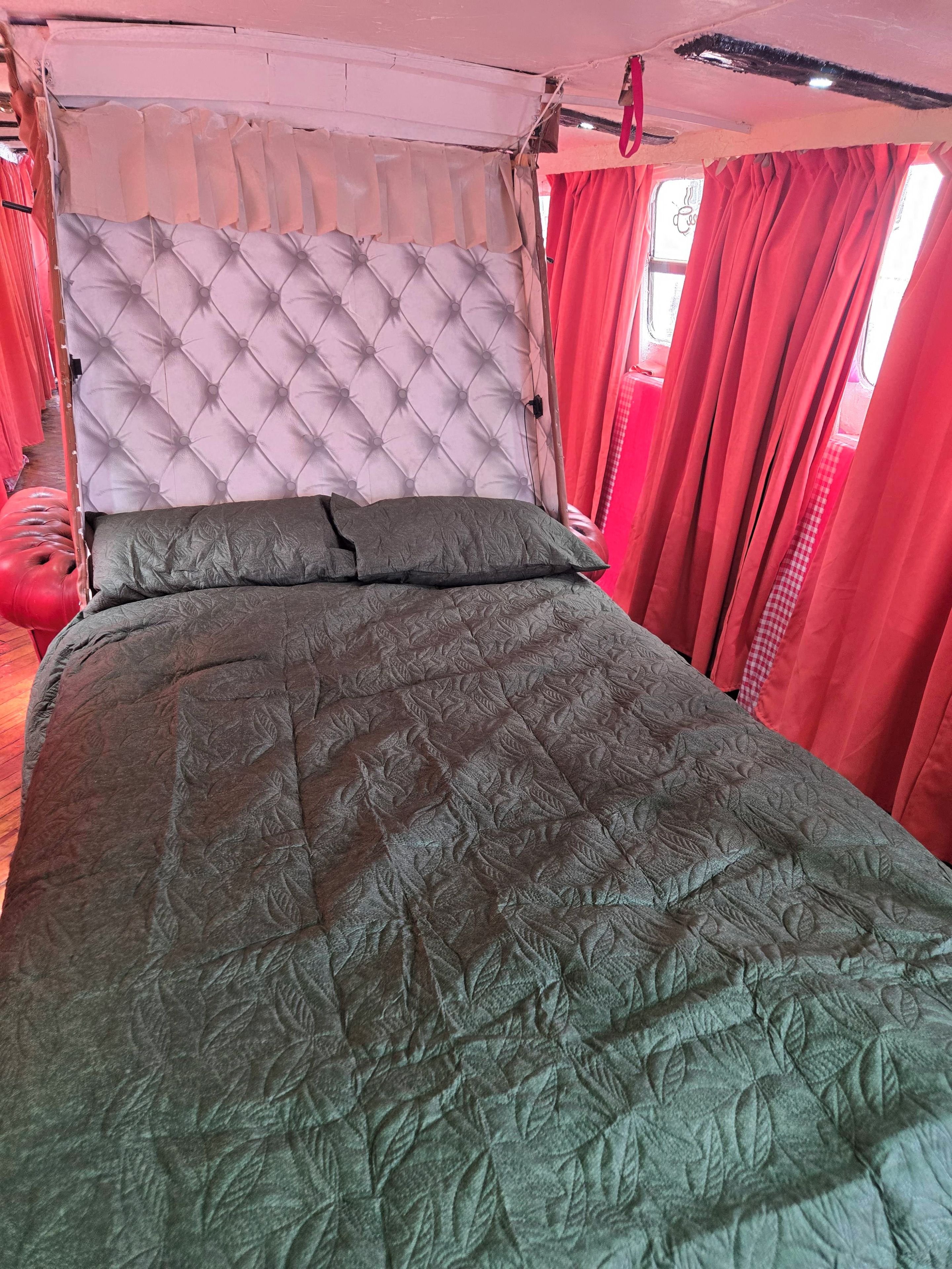 Ein Bett mit einer gesteppten Bettdecke und einem gepolsterten Kopfteil.
