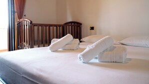 Ein Hotelzimmer mit einem Bett, Kissen und einem Holckbett.