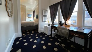 A room with a bed, a desk, a radiator, and a window with curtains. - Stylish Deluxe King Retreat in the Heart of Sacramento (Sacramento)