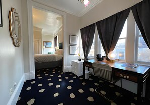 A room with a bed, a desk, a radiator, and a window with curtains. - Stylish Deluxe King Retreat in the Heart of Sacramento (Sacramento)