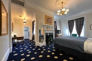 A hotel room with a polka dot carpet, a bed, a fireplace, a television, and a chandelier. - Stylish Deluxe King Retreat in the Heart of Sacramento (Sacramento)