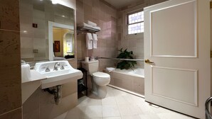 Un baño con lavabo, inodoro, bañera y ventana.