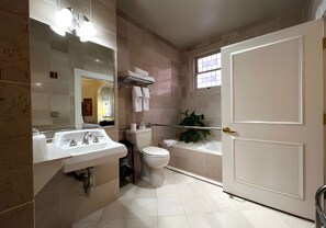 Un baño con lavabo, inodoro, bañera y ventana.