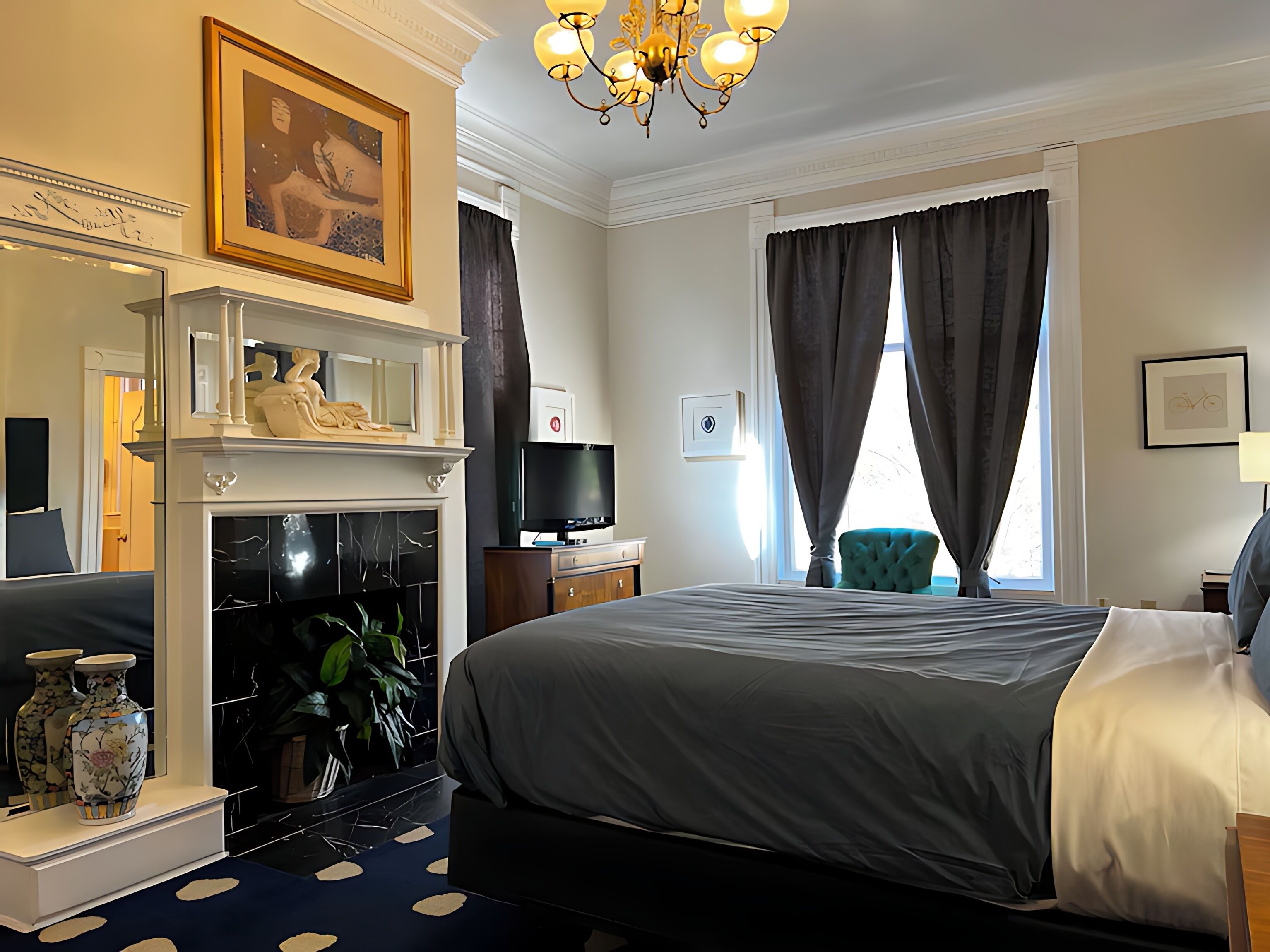 Una habitación de hotel con cama, televisión, chimenea, espejo y ventana con cortinas.