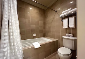 Un baño con bañera, inodoro y perchero para toallas.