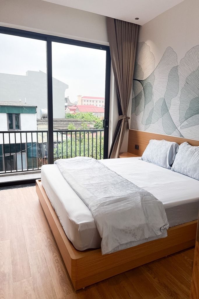 Un dormitorio con una cama grande, vistas al exterior y un papel tapiz estampado.