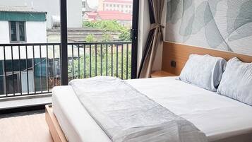 Un dormitorio con una cama grande, vistas al exterior y un papel tapiz estampado.