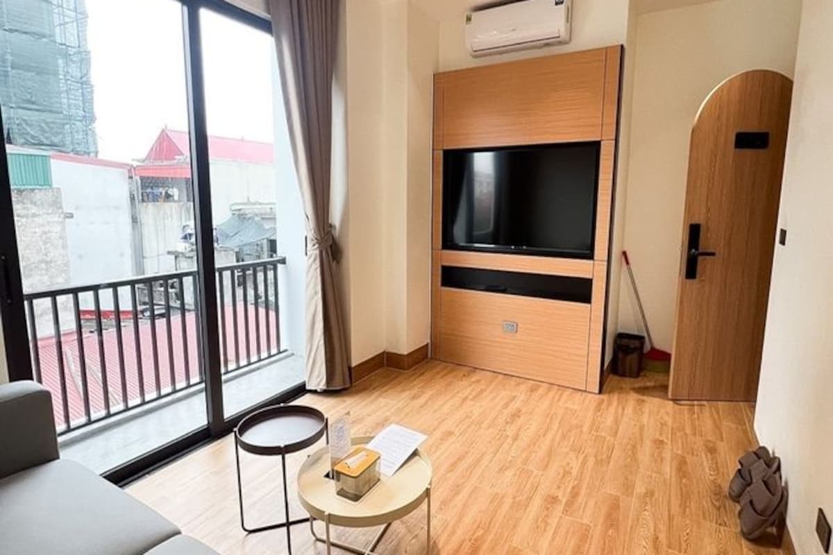 Una sala de estar moderna con sofá, televisor y balcón.