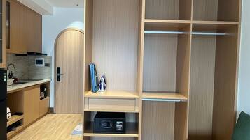 Una cocina moderna con electrodomésticos integrados, un armario de madera y una pequeña zona de estar con un cojín verde.